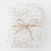 Elegante decoratieve hart bedelsels goud en wit inpakpapier vel (In situ)