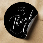 Elegante kalligrafie bruiloft dank u zwart ronde sticker<br><div class="desc">Elegante eenvoudige minimalistische zwart-wit bruiloft gunst dank u sticker met een stijlvolle chique trendy kalligrafie script.                      Eenvoudig te personaliseren met je gegevens! Geschikt voor officiële zwarte stropdas neutrale bruiloften.               Houd er rekening mee dat de achtergrond- en tekstkleuren kunnen worden gewijzigd om aan te sluiten bij uw huwelijkskleurenschema.</div>