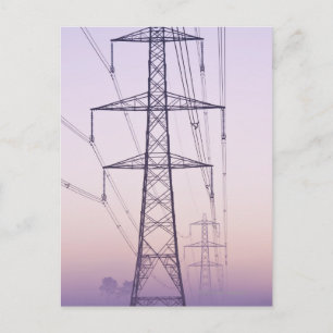 Elektriciteitspylons in mist bij zonsopgang. briefkaart