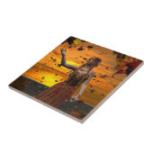 Elf in vallende bladeren tegen een herfstzonsonder tegeltje (Zijkant)