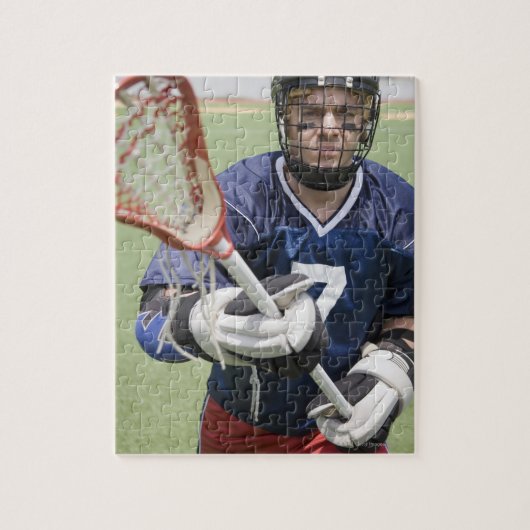 Ernstige lacrosse speler die kruis vasthoudt legpuzzel (Verticaal)