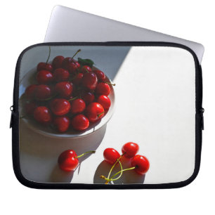 Esthetische stilleven met rijpe kersen op een witt laptop sleeve