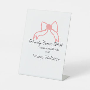 Familie komt eerst rode strik familienaam vakantie reclamebord met voetstuk