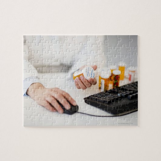 Farmaceutisch apotheker met pil flessen op compute legpuzzel (Horizontaal)