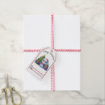 Feestelijk kerst label met een vrolijke sneeuwman cadeaulabel<br><div class="desc">Een speelse sneeuwman versierd in een feestelijk pet staat naast een prachtig versierde kerstboom,  omringd door kleurrijke geschenken,  die de sfeer van vakantiefeesten vastleggen.</div>