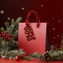 Feestelijke gouden kerstbomen op rood cadeaulabel