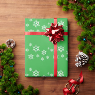 Feestelijke witte alpiene sneeuwvlokken op helder cadeaupapier