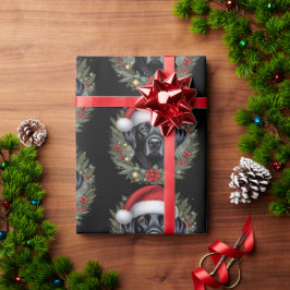 Feestelijke zwarte labrador die een kerstmuts draa cadeaupapier