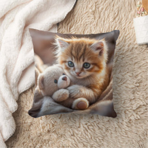 Fluffy rode katje speelt met een kleine teddybeer, kussen
