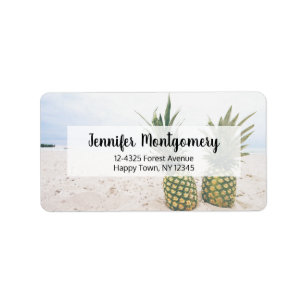 Foto van 2 ananassen op een strand adres etiket