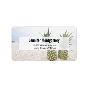 Foto van 2 ananassen op een strand adres etiket