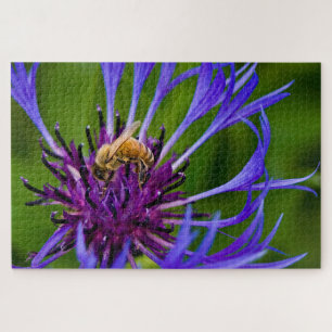 Foto van een mooie paarse bloem met honingbij legpuzzel