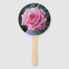 Foto van een roze roos op een handheld fan handwaaier