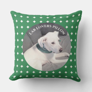 Foto van mooie witte hond groen en grijs kussen