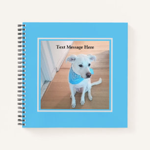 Foto van zoete witte puppy hond met babyblauwe sja notitieboek