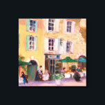 Franse Cafe Canvas Afdruk<br><div class="desc">Square French café in a country town. Een restaurant in de openlucht,  ondersteund door een vrij geel met een groen gesloten gebouw. Art door REIFSNYDER©</div>