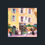 Franse Cafe Canvas Afdruk<br><div class="desc">Square French café in a country town. Een restaurant in de openlucht,  ondersteund door een vrij geel met een groen gesloten gebouw. Art door REIFSNYDER©</div>