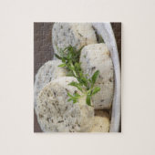 Franse geitenkaas - chevre - met kruiden op een legpuzzel (Verticaal)