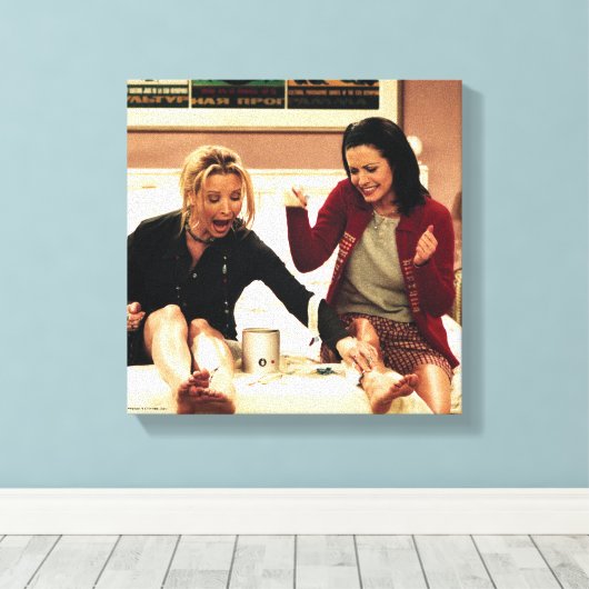 FRIENDS™ | Phoebe en Monica Waxing Legs Canvas Afdruk (Insitu (Houten vloer))
