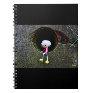 Fubby poppetje dat in een muur zit. notitieboek