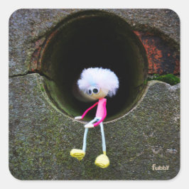Fubby poppetje dat in een muur zit.  vierkante sticker