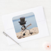 Fubby rock gitarist met hoed op het strand. vierkante sticker (Envelop)