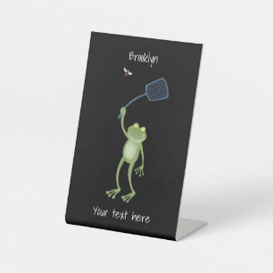 Funny green frog swatting fly cartoon reclamebord met voetstuk