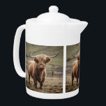 **"Furry Majesty: The Woolly Brown Highland Koe"** Theepot<br><div class="desc">Op de foto staat een wolharige,  bruine Koe in het hoogland</div>