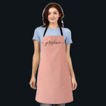 Fuzzy Peach Trendy Elegant Script Naam Schort<br><div class="desc">Ze zal van een gepersonaliseerd schort houden als ze die lekkers bakt,  heerlijke gerechten kookt of met haar planten werkt. Een perfect geschenk om haar talenten aan te moedigen. Zwart schrift voor de naam met lange staart versieringen. Fuzzy Peach kleur.</div>