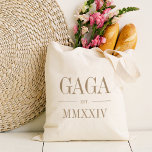 Gaga Oma Romeins cijfer jaar gevestigd Tote Bag<br><div class="desc">Een moderne minimalistische canvas tas om een chique oma te vieren,  dit schone minimalistische tas heeft "Gaga" of uw keuze van oma bijnaam in neutrale tan serif letters. Aanpassen met het jaar dat ze een grootmoeder werd onder in elegante Romeinse cijfers voor een chique touch.</div>