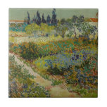 Garden in Arles door Vincent Van Gogh Tegeltje<br><div class="desc">De tuin in Arles door Vincent Van Gogh, olie op canvas 1888, is een landschapsschilderij van een kleine voetpad door een besproeiende tuin van bloembedden onder een zonnige hemel, met fruitbomen, struikgewas, cypersen en landelijke Franse gebouwen op de achtergrond. Met gevarieerde penseelstreken die de vorm, de groei en de beweging...</div>