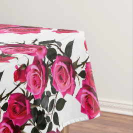 Geclusterde rode en roze rozen op een scherp wit tafelkleed
