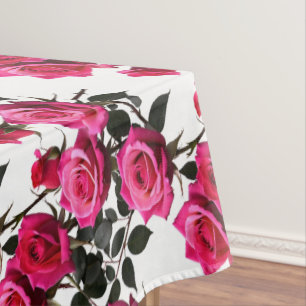 Geclusterde rode en roze rozen op een scherp wit tafelkleed