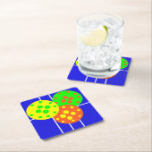 Geel, sinaasappel, & groene pickleballs op blauw h kartonnen onderzetters (Insitu)