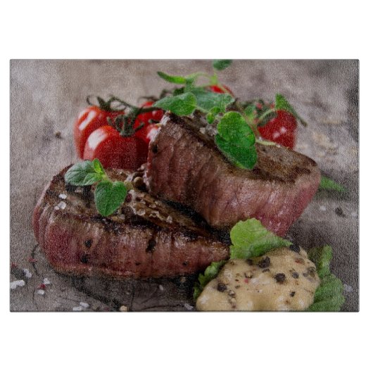 Gegrilde biefsteaks met verse kruiden en tomaten snijplank (Voorkant)