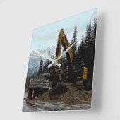 Gele graafmachine en muur-klok in de bergen vierkante klok (Hoek)