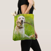 Gele labrador bespeelt zich op een stok tote bag (Dichtbij)
