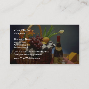 Gele picknickmand met wijn, kaas, brood en visitekaartje