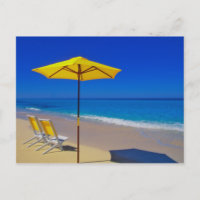 Gele strandparasol en stoelen op ongerept