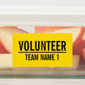Gele vrijwilligersbadge met de naam van het team v labels (Aangebracht)