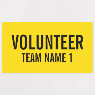 Gele vrijwilligersbadge met de naam van het team v labels