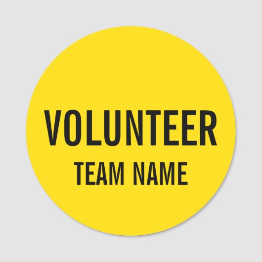 Gele vrijwilligersbadge met de naam van het team v naamplaatje (Voorkant)