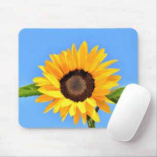 Gele zonnebloem tegen de zon aan een blauwe lucht  muismat