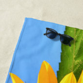 Gele zonnebloem tegen zon op blauwe hemel strandlaken (In situ)