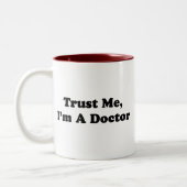 Geloof me, ik ben een dokter tweekleurige koffiemok (Links)