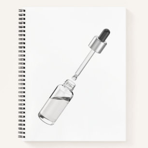 Geopende glazen druppelfles met pipet notitieboek