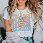 Gepersonaliseerd met naam Roze Bow Teacher Custom T-shirt<br><div class="desc">Verhoog uw leskast met onze gepersonaliseerde Met Naam Roze Bow Teacher Custom T-Shirt, een symbool van stijl en toewijding. Dit t-shirt combineert klassieke verfijning met een vleugje grilligheid, met een charmant roze strikontwerp dat een retro-coquette sfeer toevoegt. Of je nu een doorgewinterde opvoeder bent of een nieuwe leerreis begint, dit...</div>