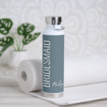 Gepersonaliseerd robuust blauw witboek Bridesmaid Waterfles<br><div class="desc">Verrassend uw trouwgaals met deze gepersonaliseerde Bridesmaid Dusty Blue White Script Water Bottle. Het is een modern, minimalistisch model met een aanpasbare blauwe achtergrond. De tekst is "bridesmaid" in groot wit, verticaal aan de linkervoorzijde. De naam is in passend trendy hand lettered manuscript op juist lager gebied. KLIK PERSONALIZE DE...</div>