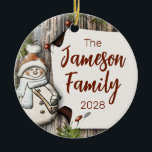 Gepersonaliseerde familienaam Christmas Snowman Keramisch Ornament<br><div class="desc">Leg de essentie van het seizoen vast met deze vertederende rustieke kerstprint, met een charmante sneeuwman in een gezellige sjaal die is neergezet tegen een achtergrond van verweerd en verdrietig hout. De combinatie van de grillige sneeuwman en de rustieke elementen roept een nostalgische en hartverwarmende vakantie ambiance op. Wat deze...</div>