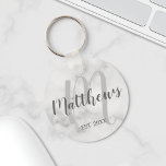 Gepersonaliseerde monogram- en familienaam marmer sleutelhanger<br><div class="desc">Gepersonaliseerde Monogram- en Familienaam Gift met familienaam in grijze moderne scriptlettertypestijl en monogram in lichte grijze moderne scriptlettertypestijl als achtergrond met een vastgesteld jaar in grijze sans serif lettertypestijl op witte marmerachtergrond. Ideaal als cadeau voor nieuwigheden,  vakantiecadeau voor familie,  gezinshereniging en cadeau voor speciale gelegenheden.</div>